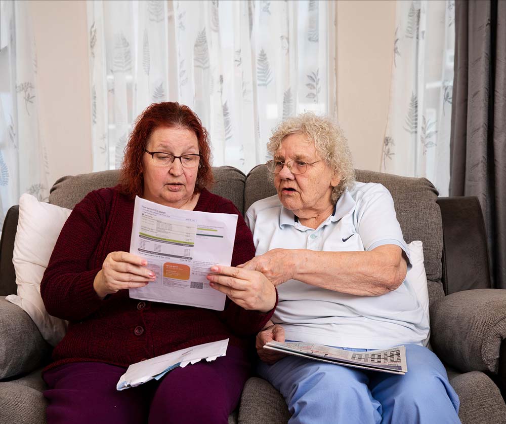 Two people on sofa with fund letter.